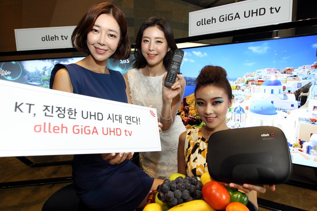 Models pose with KT’s IPTV appliances, which will allow consumers to enjoy its UHD media service beginning next month.   KT