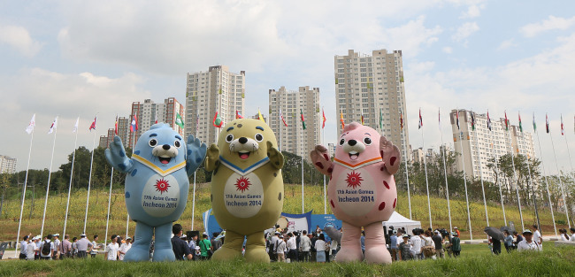 Mascots pose in front of the athletes’ village for the 2014 Asian Games in Incheon, which was unveiled to the news media Tuesday.    Yonhap