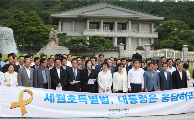 Lawmakers of the main opposition New Politics Alliance for Democracy hold a rally in front of Cheong Wa Dae in Seoul on Tuesday to ask President Park Geun-hye to help enact a new special law on the investigation into the Sewol ferry disaster. (Yonhap)
