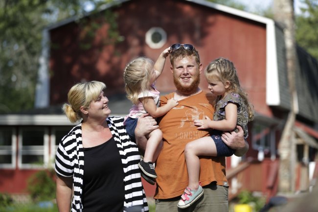 Justin Jackson poses with his wife, Heather Chapman-Jackson, and their daughters Dylan Jackson (left), 20 months, and Drew Jackson (right), 3, outside their home on Aug. 13.   Chicago Tribune/MCT
