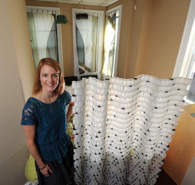 Tiffany Threadgould, chief design junkie for Trenton-based Terracycle, which turns hard-to-recycle materials into affordable green products, poses for a portrait in the bedroom of her apartment next to a room divider she made out of old 35mm film cannisters in Philadelphia on Aug. 5. The curtains in the background are made from tent material.   Philadelphia Inquirer/MCT