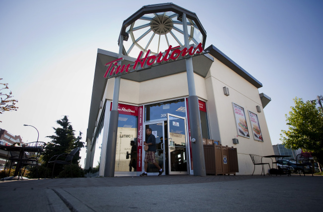 A customer exits a Tim Hortons Inc. restaurant in downtown Vancouver, British Columbia, Canada, on Tuesday, Aug. 26, 2014. Burger King Worldwide Inc. agreed to acquire Tim Hortons Inc. for about C$12.5 billion ($11.4 billion) in a deal that creates the third-largest fast-food company and moves its headquarters to Canada. Photographer: Ben Nelms/Bloomberg
A customer exits a Tim Hortons in downtown Vancouver, Canada.   Bloomberg