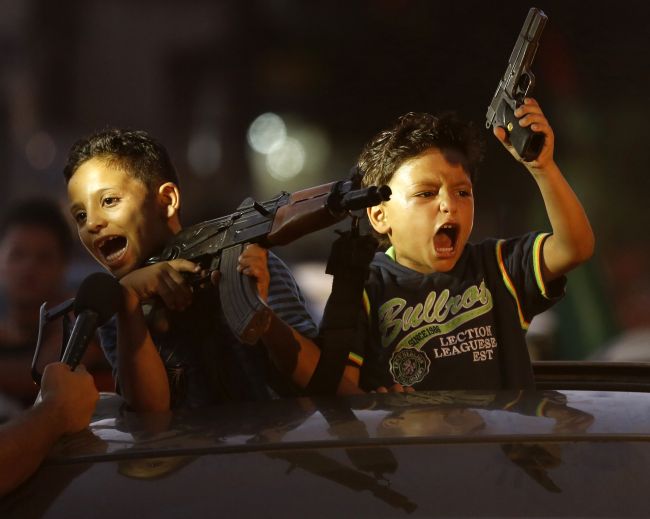 Children hold up guns (one with an empty magazine) from a car as Palestinians gather in the streets to celebrate in Gaza City after a deal had been reached between Hamas and Israel over a long-term end to seven weeks of fighting in the Gaza Strip on Tuesday.   AFP-Yonhap