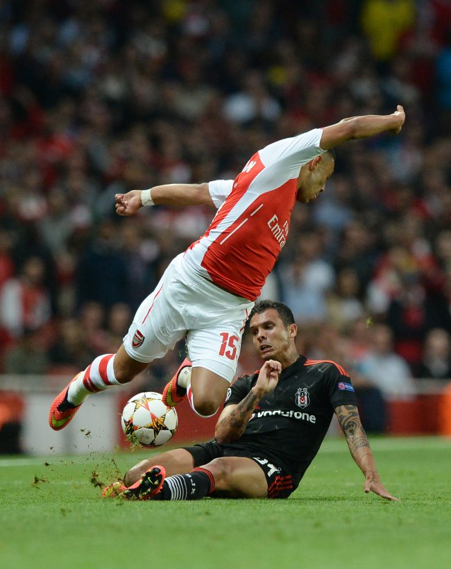 Arsenal’s Axel Oxlade-Chamberlain (top) and Besiktas’ Ramon Motta vie for the ball on Wednesday.   EPA-Yonhap