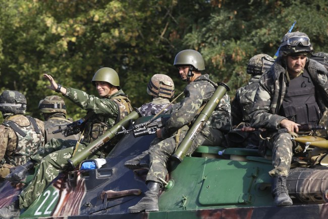 Ukrainian soldiers ride atop an armored personnel carrier near the village of Sakhanka, eastern Ukraine, Wednesday.   AP-Yonhap