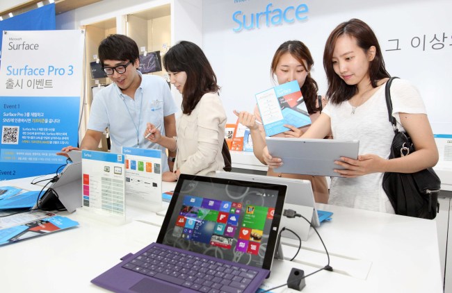 Customers look at Microsoft’s laptop/tablet hybrid Surface Pro 3 at a retail store in Seoul.   Microsoft