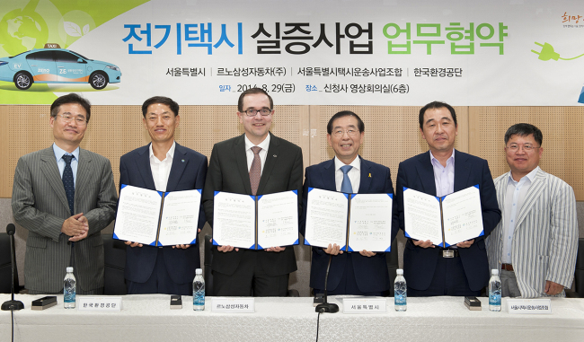 Renault Samsung Motors’ CEO Francois Provost (third from left) poses with Seoul City Mayor Park Won-soon (fourth from left) and others after signing an MOU marking their partnership in operating electric-powered taxis.  Renault Samsung Motors