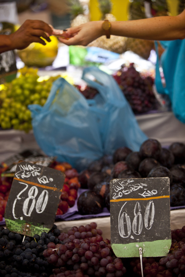 A shopper makes a purchase at a fruit and vegetable stand at a market in Rio de Janeiro, Brazil.   Bloomberg