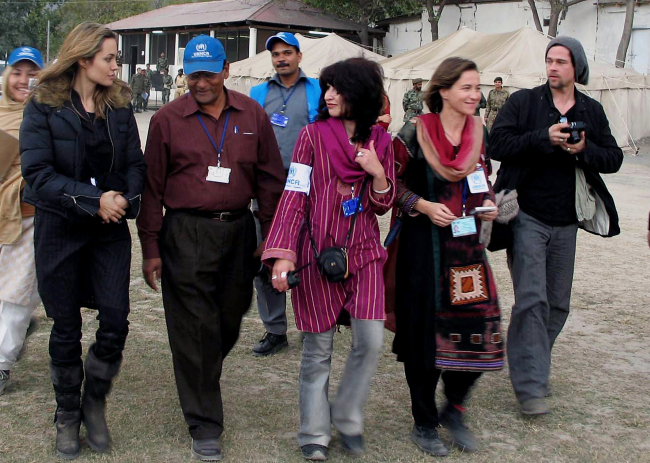 In this Nov. 26, 2005, file photo, Hollywood actress Angelina Jolie (left) and actor Brad Pitt (right) are escorted by UNHCR officials toward a helicopter in Muzaffarabad, Pakistan, after seeing an earthquake-affected area.    AP-Yonhap