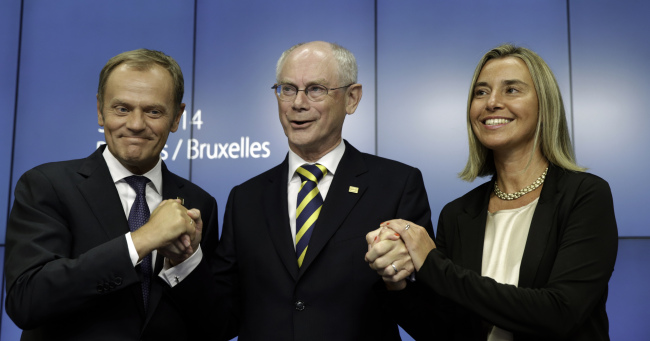 European Council President Herman Van Rompuy (center) holds the hands of Polish Prime Minister Donald Tusk (left) and Italian Foreign Minister Federica Mogherini during a news conference at an EU summit in Brussels on Saturday.   AP-Yonhap