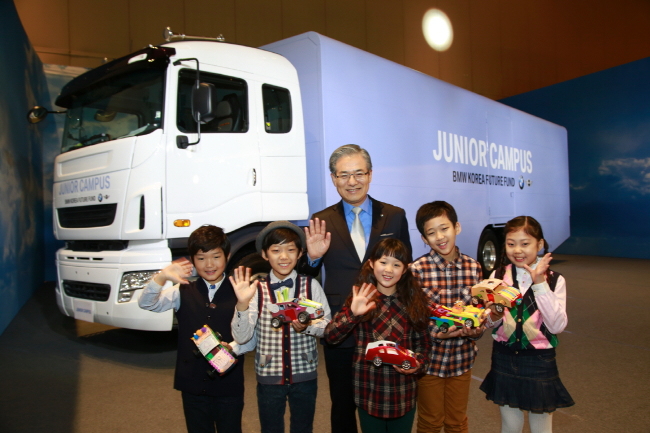 BMW Korea CEO Kim Hyo-joon poses with children to celebrate the launch of the Junior Campus program.   BMW Korea