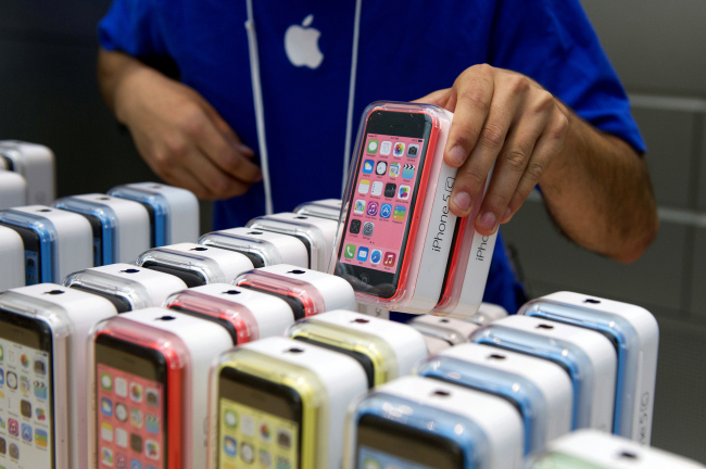 An employee arranges Apple iPhone 5C and 5S devices at the company’s store in Palo Alto, California.   Bloomberg
