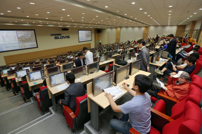 Dealers participate in an automobile auction at Hyundai Glovis’ auction house in Yangsan, South Gyeongsang Province.   Hyundai Glovis