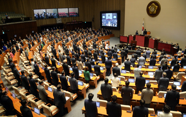 Lawmakers pledge allegiance to the national flag at the opening ceremony for the 100-day regular parliamentary session at the National Assembly on Monday. The ruling and opposition parties remain at odds over the special Sewol bill, which has created a monthslong deadlock.   Lee Gil-dong/The Korea Herald