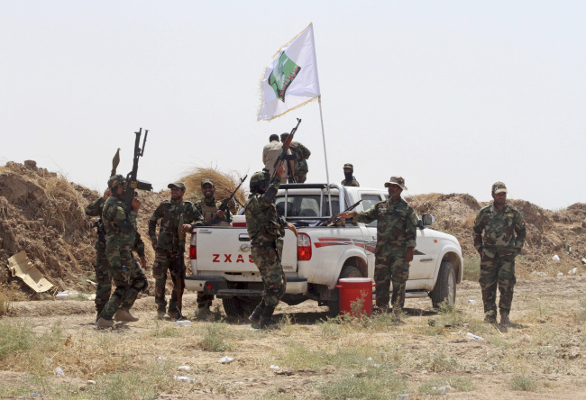 Iraqi security forces and Shiite militiamen chant slogans after breaking the siege of 15,000 Shiite Turkmens stranded in the town of Amirli, 170 kilometers north of Baghdad, Sunday.   AFP-Yonhap