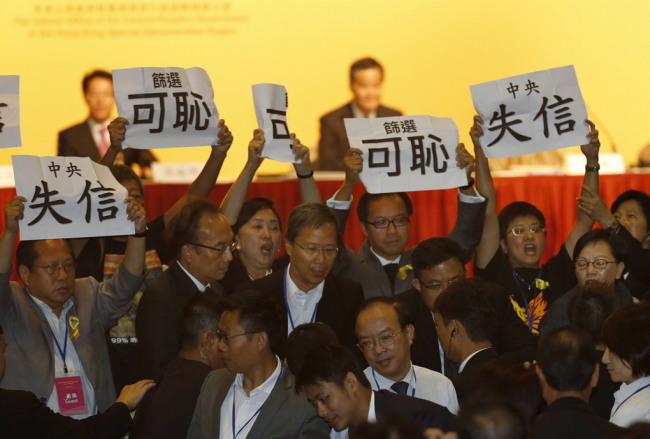 Pro-democracy lawmakers display placards against Li Fei, deputy secretary general of the National People’s Congress' Standing Committee, during a briefing session in Hong Kong, on Monday.  (AP-Yonhap)
