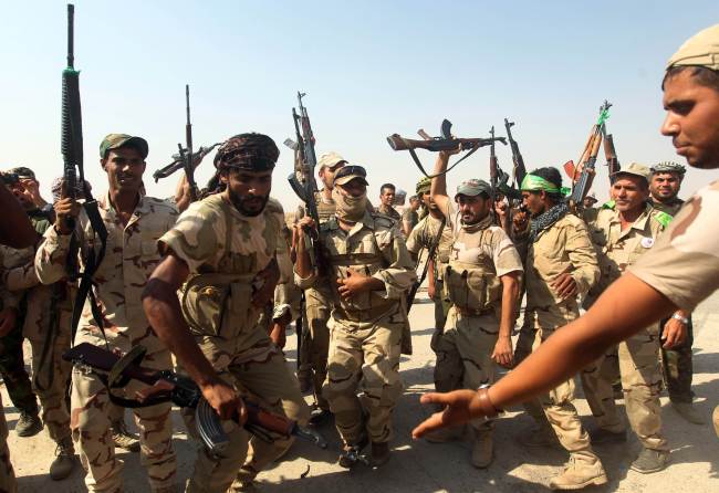 Iraqi volunteer fighters celebrate the breaking of the jihadist siege of the Shiite town of Amerli as they advance toward the town from the position in the Ajana area, south of Amerli in Salaheddin province, Iraq, Monday.   AFP-Yonhap