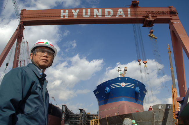 An employee works in front of a ship under construction at Hyundai Heavy Industries’ shipyard in Ulsan.   Bloomberg