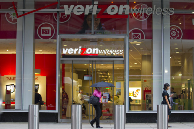 Pedestrians walk past a Verizon Wireless store in New York.   Bloomberg