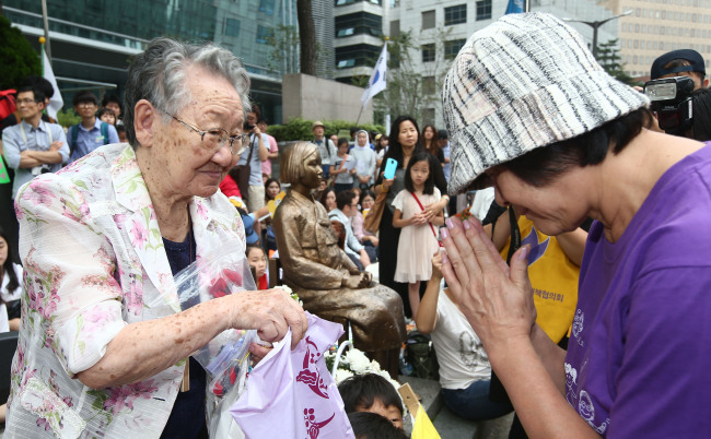 Gil Won-ok (left), a former “comfort woman,” greets a Japanese activist during a rally in front of the Japanese Embassy in central Seoul on Aug. 20.   Yonhap