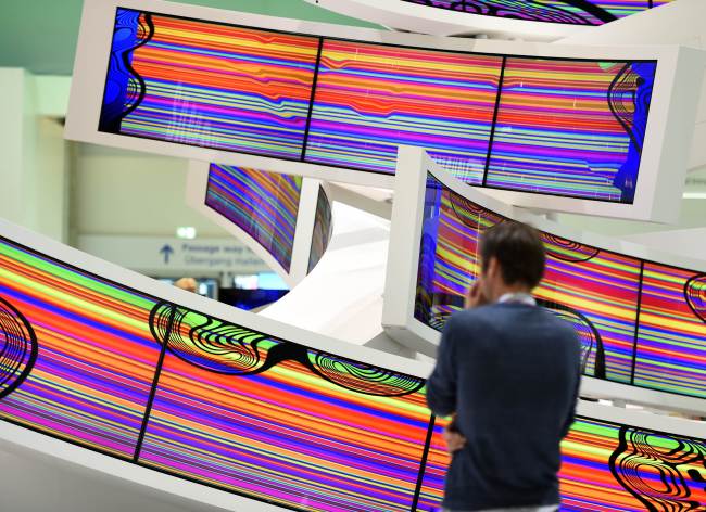 A visitor stands in front of curved television sets Electronics’ booth during the IFA consumer electronics trade fair in Berlin on Sept. 5.   AFP-Yonhap