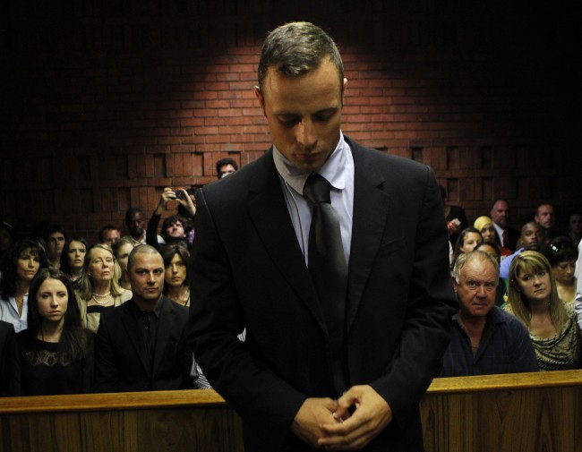 Oscar Pistorius stands ahead of court proceedings at the Pretoria magistrates court, in this Feb. 22, 2013, file photo.