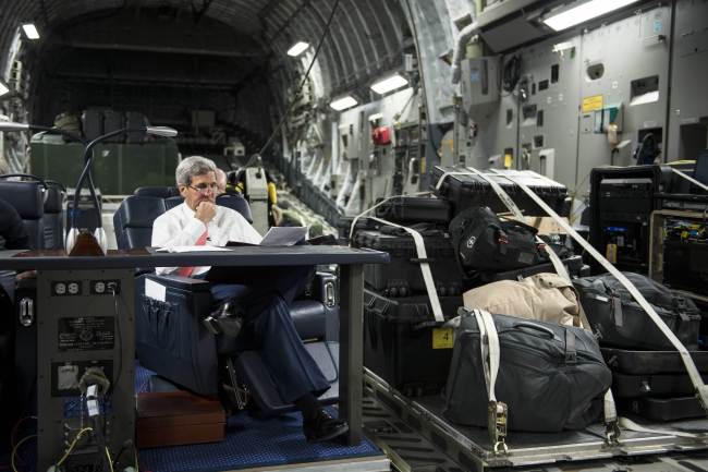 U.S. Secretary of State John Kerry looks over papers while flying from Jordan to Iraq on Wednesday.   AFP-Yonhap