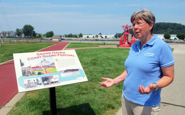 Grand Haven, Michigan, Mayor Geri McCaleb stands beside the Grand River’s waterfront, where a sign describes the
town’s annual Coast Guard festival. McCaleb is skeptical that humans are causing the climate to heat up, but says
she’s willing for Grand Haven officials to work with outside consultants on a plan to prepare for heavier storms and
other consequences of a warmer planet. (AP)