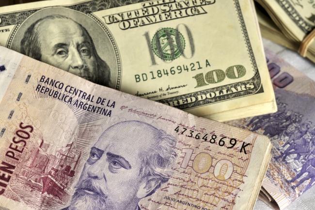 Argentine peso notes and $100 bills.   Bloomberg