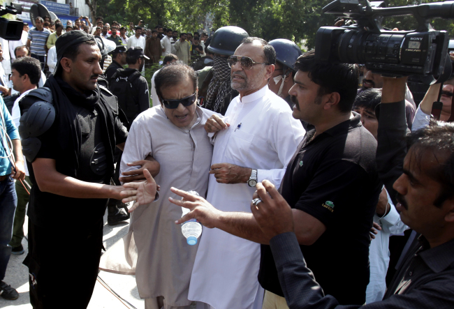 Pakistani police officers apprehend opposition leaders trying to block a prison van full of antigovernment activists in Islamabad on Saturday.   AP-Yonhap