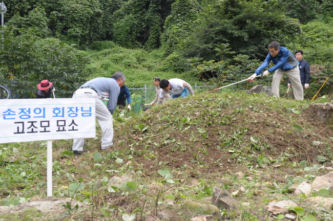 Officials at Dong-gu District Office in Daegu weed the tomb of the great-great-grandfather of SoftBank founder Masayoshi Son on Aug. 31.   Dong-gu District Office