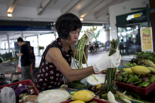 A vendor arranges vegetables at an organic market in Hong Kong. (AFP)