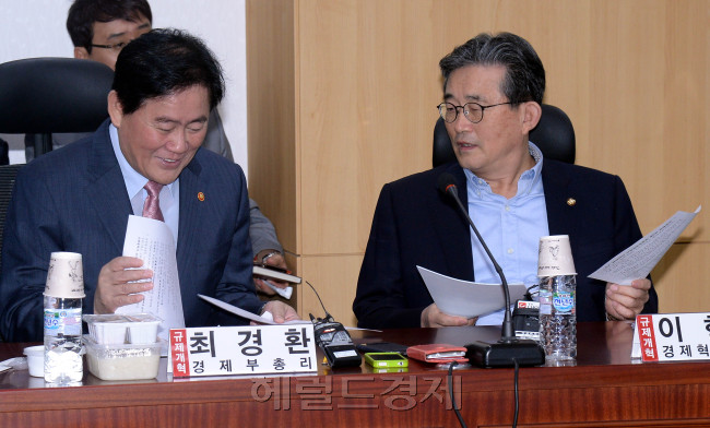 최경환 경제부총리겸 기획재정부장관이 16일 오전 국회에서 열린 경제혁신 규제개혁위원회 제5차 전체회의에 참석해 이한구 경제혁신특별위원회위원장과 이야기를 하고 있다.이길동기자.gdlee@heraldcorp.com
최경환 경제부총리겸 기획재정부장관이 16일 오전 국회에서 열린 경제혁신 규제개혁위원회 제5차 전체회의에 참석해 이한구 경제혁신특별위원회위원장과 이야기를 하고 있다.이길동기자.gdlee@heraldcorp.com
새누리당이 기존의 규제개혁 적용대상을 중앙행정부처 뿐 아니라 ‘그림자 규제’로 꼽혔던 국회와 법원, 감사원 등 헌법기관도 포함시키는 규제개혁특별법을 발의한다. 특별법이 국회 본회의를 통과하면 정부와 광역자치단체의 업무평가에는 규제개혁평가 결과가 반영되고, 대통령 직속 기관인 규제개혁위원회의 권고 사항을 이행하지 않는 부처는 감사원의 감사를 받는다.
새누리당 경제혁신특위 규제개선분과는 정부와 이 같은 내용의 규제개혁특별법을 마련키로 하고, 16일 각계 의견을 수렴하기 위한 공청회를 개최했다.
이날 공청회에 참석한 새누리당 김무성 대표는 “손톱 밑 가시를 뽑아야 한다고 하는데 그 차원을 넘어 거대한 규제 암반을 다이너마이트로 폭파시켜야만 살 수 있다”며 정부의 강력한 규제개혁 방침에 여당의 적극적인 협조 의사를 내비쳤다. 당정은 올해 정기국회에서 특별법을 통과하기로 하는 데 의견을 모았다. 특별법에는 현재 대통령 직속이지만 자문 성격에 그치고 있는 규제개혁위원회 대신 행정집행권을 가진 ‘장관급 상설기구’를 설치하는 내용이 포함된다. 정권이 바뀌어도 영속할 수 있는 처로 만들어 위원장은 국무총리가 맡되, 부위원장을 장관급으로 격상하는 방안이다.
아울러 여러 부처에 걸쳐 있어 없애기 힘든 소위 ‘덩어리 규제’를 없애는 관련 법률 일괄 개정 근거도 담겼다. 규제개선의 사각지대에 있던 지자체에도 규제비용총량제가 적용되고, 더 나아가 해당 부처는 존재 이유를 입증하지 못하는 규제를 자동으로 퇴출시킬 수 있게 된다.
이와 관련 이날 공청회에 참석한 각계 패널은 새누리당이 정부가 추진하는 행정규제기본법 개정안보다 권한이 대폭 강화된 규제개혁위를 마련했다는 데 공감했다. 다만 법원과 헌법재판소, 국회가 국민을 상대로 하는 데 어떤 행정규제를 하는지 세심하게 명시되지 않을 경우 위헌의 소지가 남아있다는 우려의 목소리도 나왔다.
패널토론에 참가한 김기홍 국회입법조사처 경제산업조사실장은 “헌법상 독립이 철저히 보장돼야 하는 법원과 헌법재판소에 대한 간섭이 가능하게 되면 헌법에서 사법권독립을 정한 취지에 반할 우려가 크다”며 “헌법기관은 소관법률에서 자체적으로 규제개혁을 할 수 있도록 해야 한다”고 지적했다. 홍윤식 국무조정실 국무차장도 “헌법기관이 내부 규칙을 통해 실천방안을 강구하는 구체적인 조치가 필요하다”고 꼬집었다.
아울러 규제개혁을 위한 기본적인 원칙과 적용 방안이 보다 세심하게 정립돼야 한다는 필요성이 다수 제기됐다. 김현수 국민대 경영학부 교수는 “규제비용을 측정하기도 어려운 상황”이라며 ”규제비용총량제가 효과적으로 적용될 수 있도록 시행령과 시행규칙이 보완돼야 한다”도 말했다.
한편 공청회에 앞서 열린 당 경제혁신특위 전체회의에서 최경환 경제부총리는 “정부는 대통령을 필두고 규제와의 대전을 치르고 있다고 해도 과언이 아니다”라며 “새누리당의 중심이 돼 규제개혁 법안을 마련해 정부로선 천군만마를 얻은 듯한 기분”이라고 말했다. 강력한 규제개혁 추진동력을 마련한 당의 제정안에 환영의 뜻을 내비치면서 ‘과도한 규제를 걷어내겠다’는 정부의 방침을 재차 시사한 셈이다.
이정아 기자/dsun@heraldcorp.com