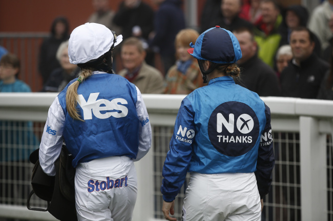 Jockeys Carol Bartley, right, and Rachel Grant, left, pose for photographs in pro-independence "yes" campaign colors, and anti-independence"no" campaign colors before racing at Musselburgh racecourse, in a publicity event arranged by Ladbrokes Plc, in Edinburgh, U.K., on Monday, Sept. 15, 2014. U.K. Prime Minister David Cameron returned to Scotland today on his last visit to save the union and prevent the biggest redrawing of the political map of western Europe since World War II. Photographer: Simon Dawson/Bloomberg *** Local Caption *** Carol Bartley; Rachel Grant
Jockeys Carol Bartley (right) and Rachel Grant pose for photographs in pro-independence “Yes” campaign colors, and anti-independence“No” campaign colors before racing at Musselburgh racecourse, in a publicity event arranged by Ladbrokes Plc. in Edinburgh on Monday.   Bloomberg