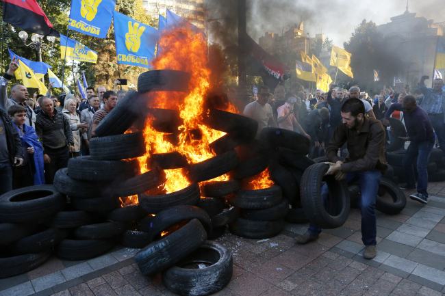 Ukrainian protesters burn tires outside the Ukrainian parliament in Kiev on Tuesday.   AP-Yonhap