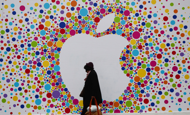 A pedestrian carries a shopping bag as she passes a giant Apple Inc. logo outside a new Apple store on Princess Street in Edinburgh.   Bloomberg