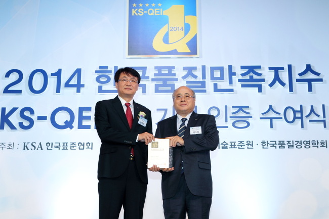 KT marketing executive Han Jun-seok (left) poses after the company was recognized for its superb mobile and Internet services Thursday.   KT