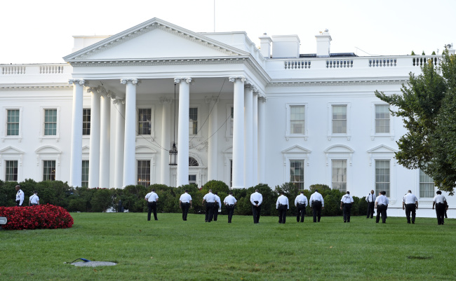 Uniformed Secret Service officers walk along the lawn on the north side of the White House in Washington on Saturday.    AP-Yonhap