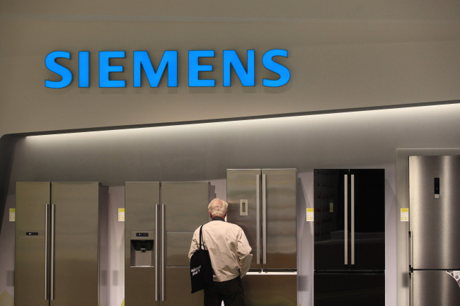 A visitor inspects home appliances, manufactured by Siemens AG, at the company’s trade stand at the IFA Consumer Electronics Fair in Berlin on Sept. 3.    Bloomberg