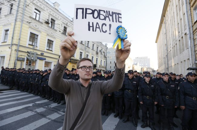 A man holds a poster reading “Forgive us” in front of police during an antiwar rally in Moscow, Russia, Sunday.   EPA-Yonhap