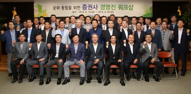 NH Financial Group chairman Yim Jong-yong (front row, fourth from right) poses with NH executives at a workshop held at its headquarters in Seoul on Friday.    NH Financial Group