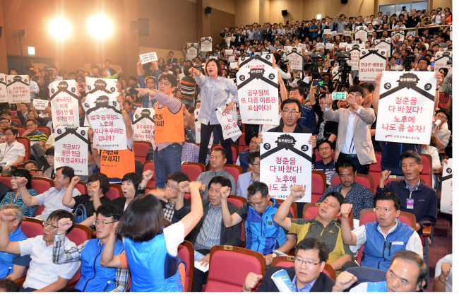 Unionized government officials protest the ruling Saenuri Party’s plans to reform the civil servant pension system at the National Assembly in Seoul on Monday. The Korean Pension Association was to hold a debate on the new pension plans, but it was canceled after some 200 members of the public officials’ union shouted slogans and blew whistles at the venue.   Lee Gil-dong/The Korea Herald