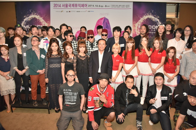 Hong Sang-pyo (center), president of Korea Creative Content Agency, poses with musicians attending the MU:CON Seoul 2014 press conference at a Seoul hotel on Monday.   KOCCA