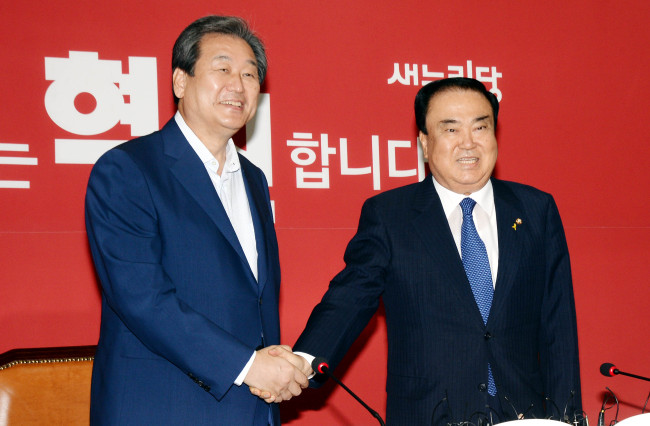 Chiefs of the country’s main parties, ruling Saenuri Party chair Rep. Kim Moo-sung (left) and interim chief of the main opposition party New Politics Alliance for Democracy Rep. Moon Hee-sang, shake hands before a meeting on Monday.   Lee Gil-dong/The Korea Herald