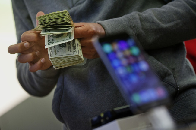A customer pays for an iPhone 6 at an Apple Inc. store in New York.     Bloomberg