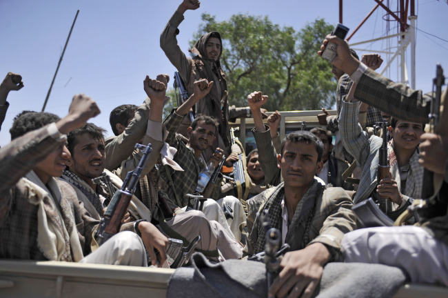 Hawthi Shiite rebels chant slogans in a pickup truck at the army’s 1st Armored Division compound, after taking it over, in Sanaa on Monday.   AP-Yonhap
