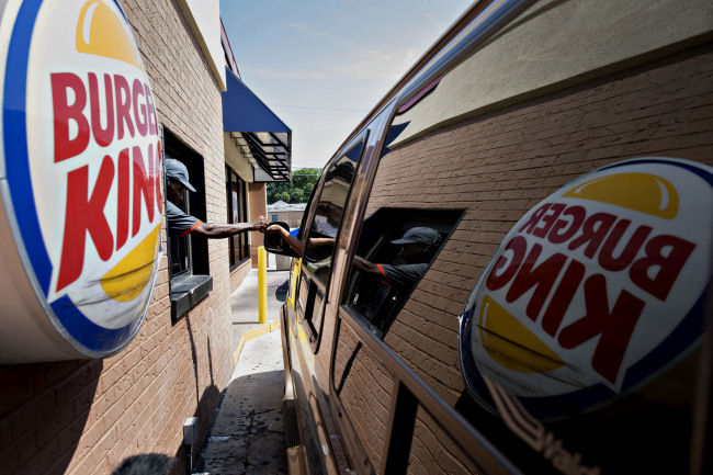 An employee assists a customer at the drive-through of a Burger King in Peoria, Illinois.   Bloomberg