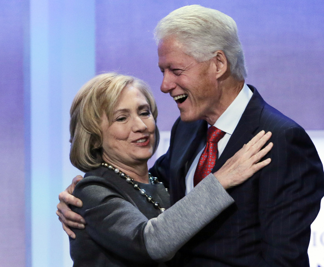 Former Secretary of State Hillary Rodham Clinton is welcomed to the stage by her husband, former U.S. President Bill Clinton, at the Clinton Global Initiative in New York on Monday.   AP-Yonhap