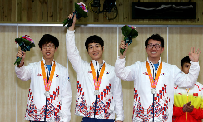 Korea’s Kim Hyeon-jun (from left), Kim Sang-do and Han Jin-seop pose with their silver medals on Tuesday.   Yonhap