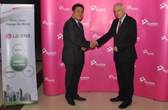 Kim Ji-seob (left), vice president of LG CNS’ smart green business unit, shakes hands with Tauron Dystrybucja CEO Piotr Kolodziej.   LG CNS